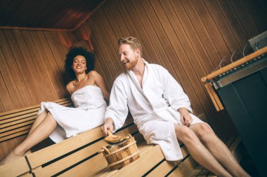 Mutlu çift rahatlatıcı bir sauna, spa resort otel lüks içinde genç. Buhar banyosunda welness gününde romantik aşıklar