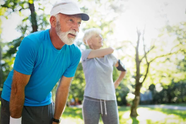 Senior couple jogging and running outdoors in nature