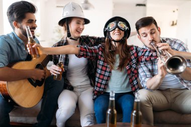 Birlikte parti ve aletleri oynamak neşeli genç arkadaşlar