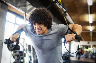 Spor salonunda egzersiz yapan mutlu fit adam