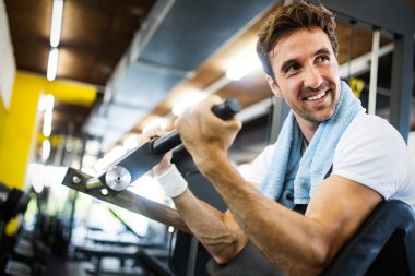 Genç çekici yetişkin adam egzersiz ve spor spor salonunda ağırlık kaldırma yapıyor