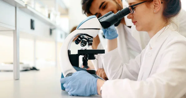 Νεαρή Γυναίκα Επιστήμονας Κοιτάζοντας Μέσα Από Μικροσκόπιο Στο Εργαστήριο — Φωτογραφία Αρχείου
