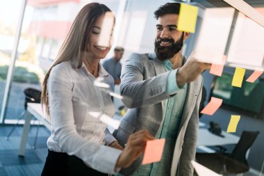 Modern ofis lobisinde iş adamları belgeler üzerinde tartışıyor..