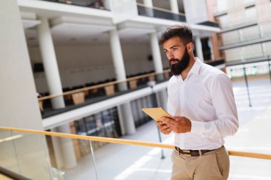Yakışıklı genç işadamı dijital tablet onun şirket içinde kullanma