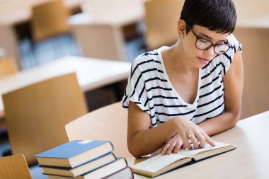 Bir çok gülümseyen kız okuma kitabı kapalı kitaplığındaki portresi