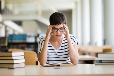 güzel bir kadın kütüphanede kitap okuma