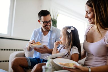 Mutlu aile birlikte evde pizza paylaşımı gülümseyen