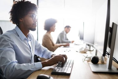 Modern bilişim şirketinde işbirliği yapan programcılar uygulama geliştiriyor