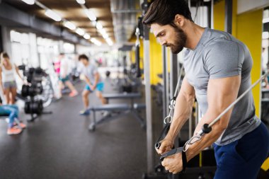 Spor salonunda egzersiz yapan genç yakışıklı güçlü erkek