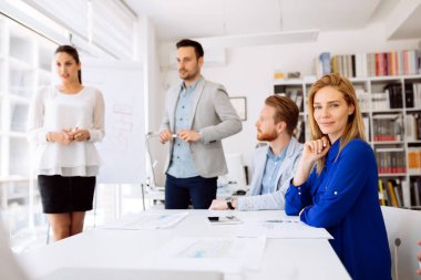 Ofisteki iş adamları bir konferans düzenleyip stratejileri tartışıyor