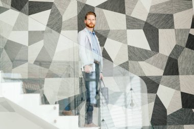 Office ayakta merdivenlerde giderken kendine güvenen iş adamı