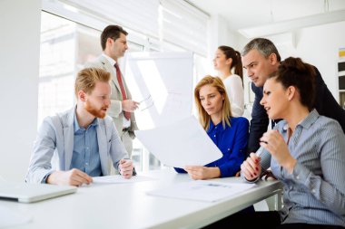 Ofisteki iş adamları bir konferans düzenleyip stratejileri tartışıyor