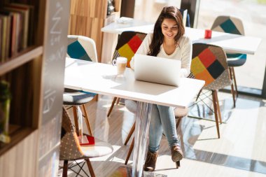 Güzel genç şirin esmer dizüstü Kitaplığı'nda eğitim