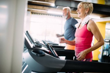 Olgun insanlar fitness spor kulübünde makine treadmill çalışan