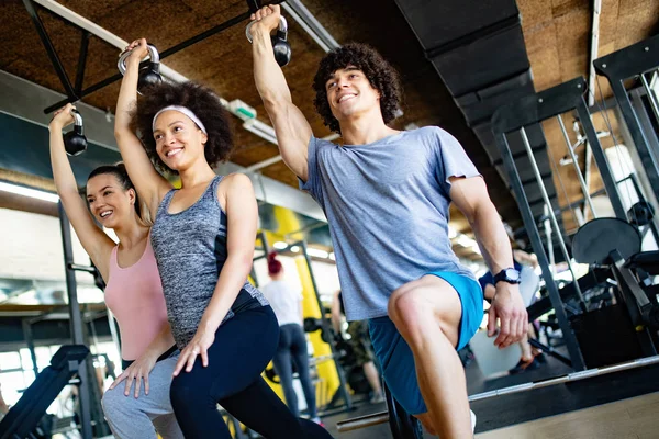 Modern spor salonunda eğitim gören bir grup insan.