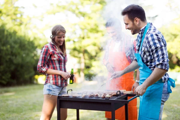 Νέους ανθρώπους που απολαμβάνουν barbecuing — Φωτογραφία Αρχείου