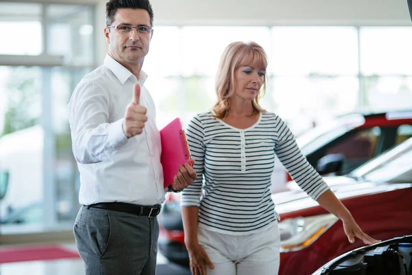 Customer looking at cars at dealership — Stock Photo, Image