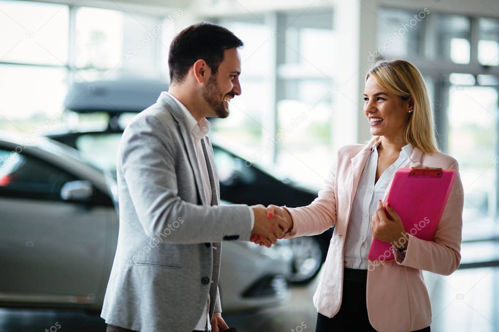 Picture of professional female salesperson working in car dealership