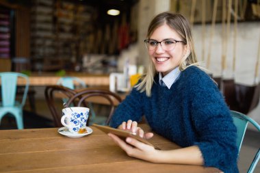 Dijital tablet kullanan genç çekici kadın portresi