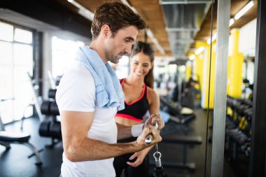 Fit kadın kişisel antrenör spor salonunda adam yardım