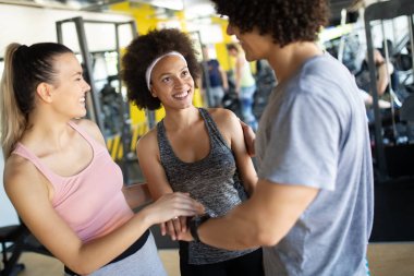 Spor salonunda egzersiz yapan bir grup sağlıklı genç.