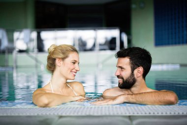Mutlu çekici çift rahatlatıcı spa yüzme havuzunda
