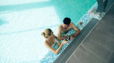 Mutlu çekici çift rahatlatıcı spa yüzme havuzunda