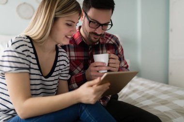 Genç çekici çift yatak odasında dijital tablet kullanma