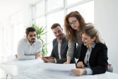 Bir grup mimar ve iş adamı birlikte çalışıyor ve beyin fırtınası yapıyorlar.