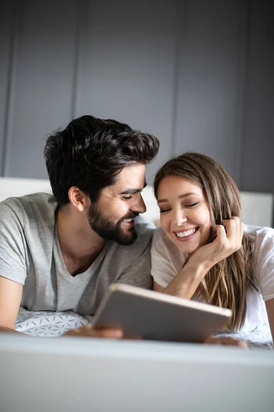 Allegro Coppia Cerca Tablet Insieme Ridendo Mentre Sdraiato Sul Letto — Foto Stock