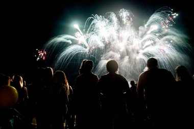 Kalabalık havai fişekleri izliyor ve geceleri kutlama yapıyor.