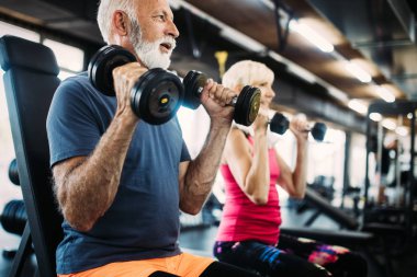 Olgun erkek ve kadın spor salonunda egzersizleri yapıyor sağlıklı kalmak için uygun