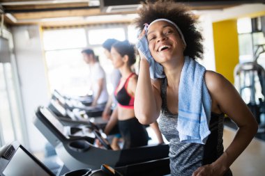 Spor salonunda egzersiz yapan bir grup mutlu fit insan.
