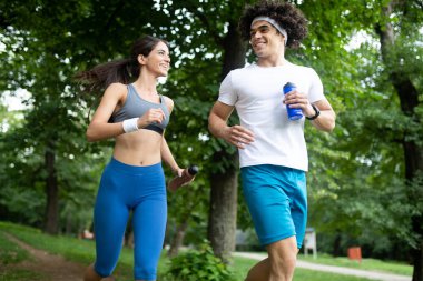 Genç insanlar sağlıklı kalmak için doğada koşuyor ve egzersiz yapıyorlar.