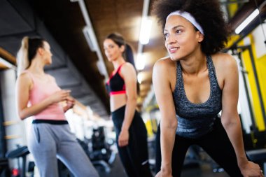 Spor salonunda egzersiz yapan bir grup genç.