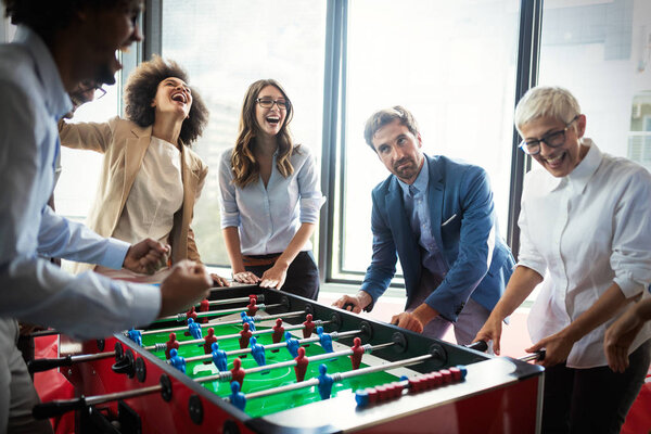 Excited diverse employees laughing enjoying funny activity at work break, creative friendly workers play game together