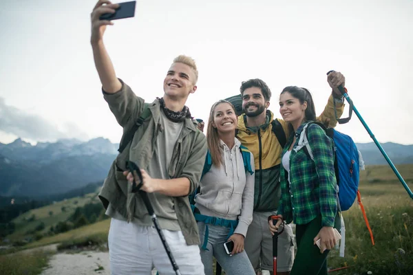 Travel, tourism, hike and people concept - happy group of friends taking selfie