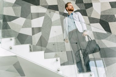 Office ayakta merdivenlerde giderken kendine güvenen iş adamı