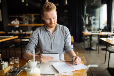Kafede notlar alarak ve fikirleri aşağı işadamı