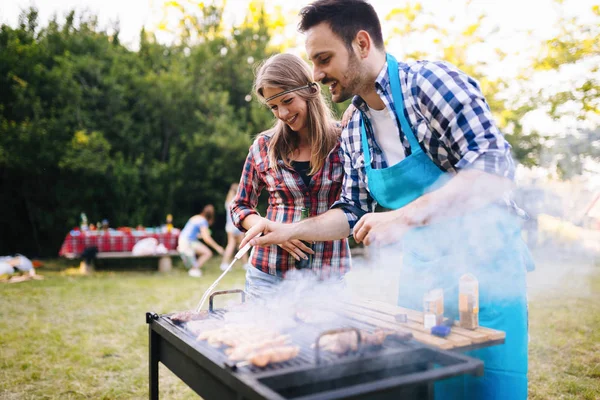 Unga människor njuta av grillning — Stockfoto