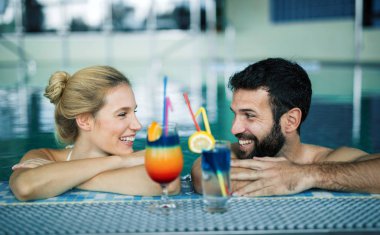 Mutlu çekici çift rahatlatıcı spa yüzme havuzunda