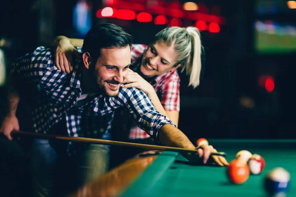 年轻迷人的情侣一起玩台球在酒吧 — 图库照片