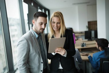 İş adamları ofiste dijital tablet kullanırken tartışıyor