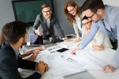 Bir grup mimar ve iş adamı birlikte çalışıyor ve beyin fırtınası yapıyorlar.