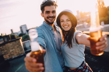 Mutlu çift zevk içecekler ve balkon parti.