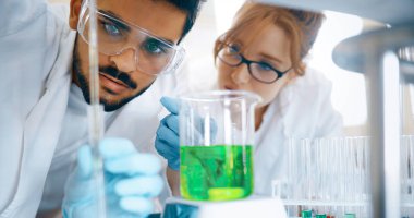 Laboratuvarda birlikte çalışan genç kimya öğrencileri.