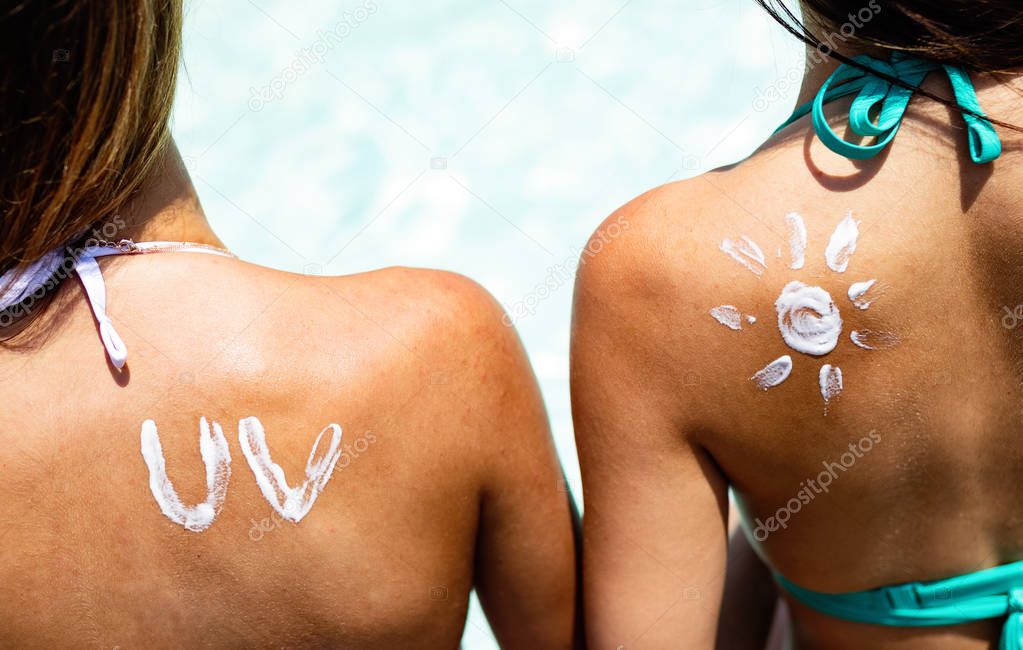 Attractive woman with healthy skin applying sunscreen against sunburn
