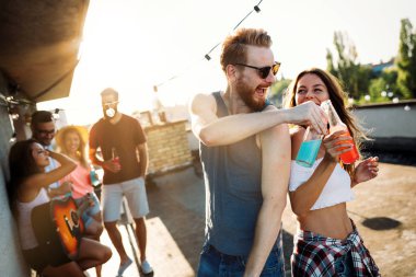 Grup arkadaşıyla birlikte eğleniyor. Çatı partide eğleniyor arkadaşlar.