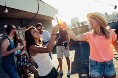 Grup arkadaşıyla birlikte eğleniyor. Çatı partide eğleniyor arkadaşlar.