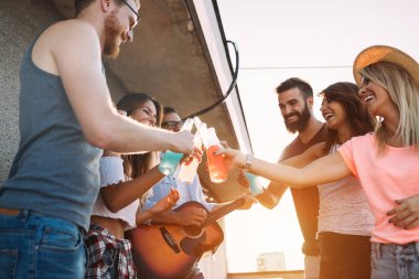 Grup arkadaşıyla birlikte eğleniyor. Çatı partide eğleniyor arkadaşlar.